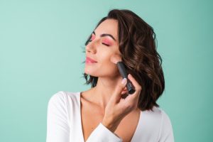 Mujer aplicándose colorete