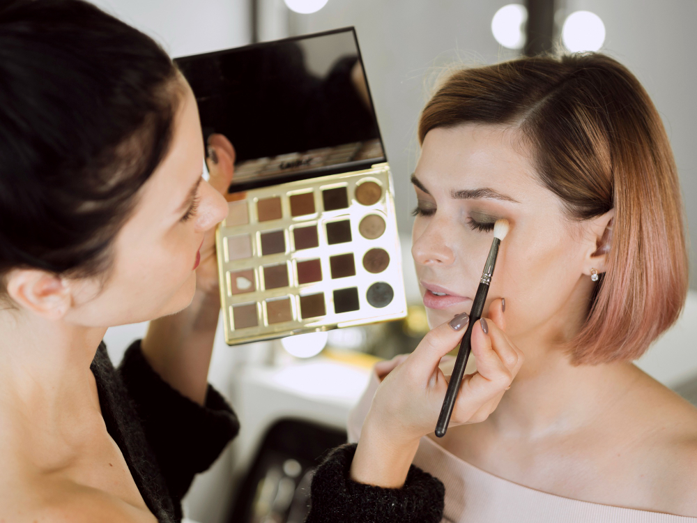 Alumna practicando con una paleta de sombras en un curso de maquillaje