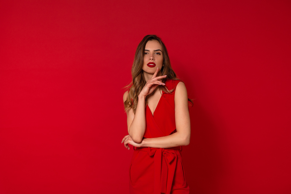 Mujer con vestido rojo y maquillaje a juego sobre fondo rojo