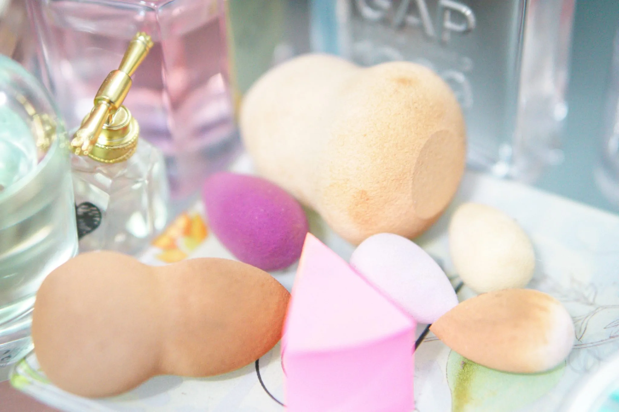Esponjas de maquillaje de colores junto a productos de belleza