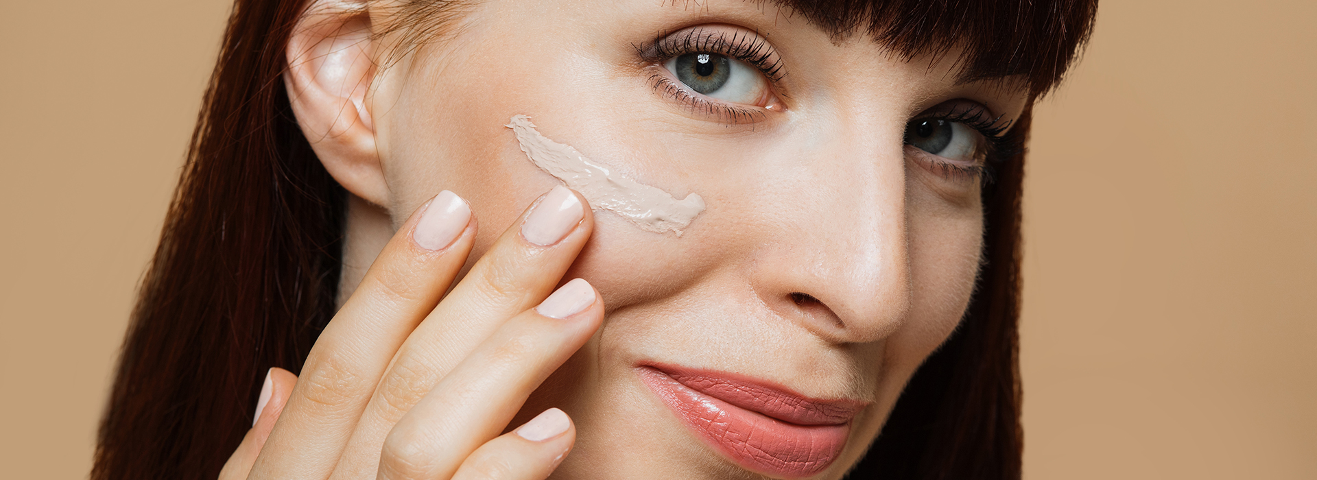 Mujer probándose una base de maquillaje en la mejilla