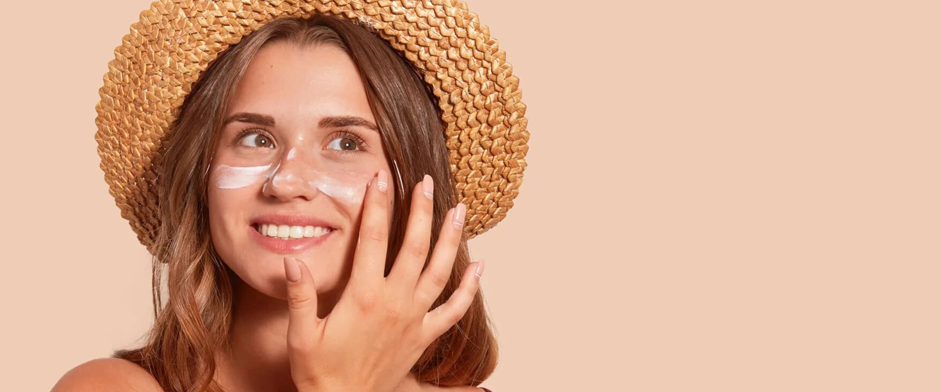 Mujer con sombrero de paja tocándose la piel del rostro