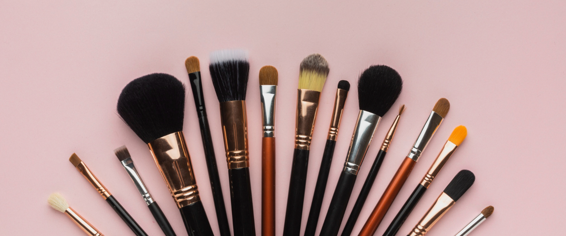 Conjunto de brochas de maquillaje limpias sobre fondo rosa