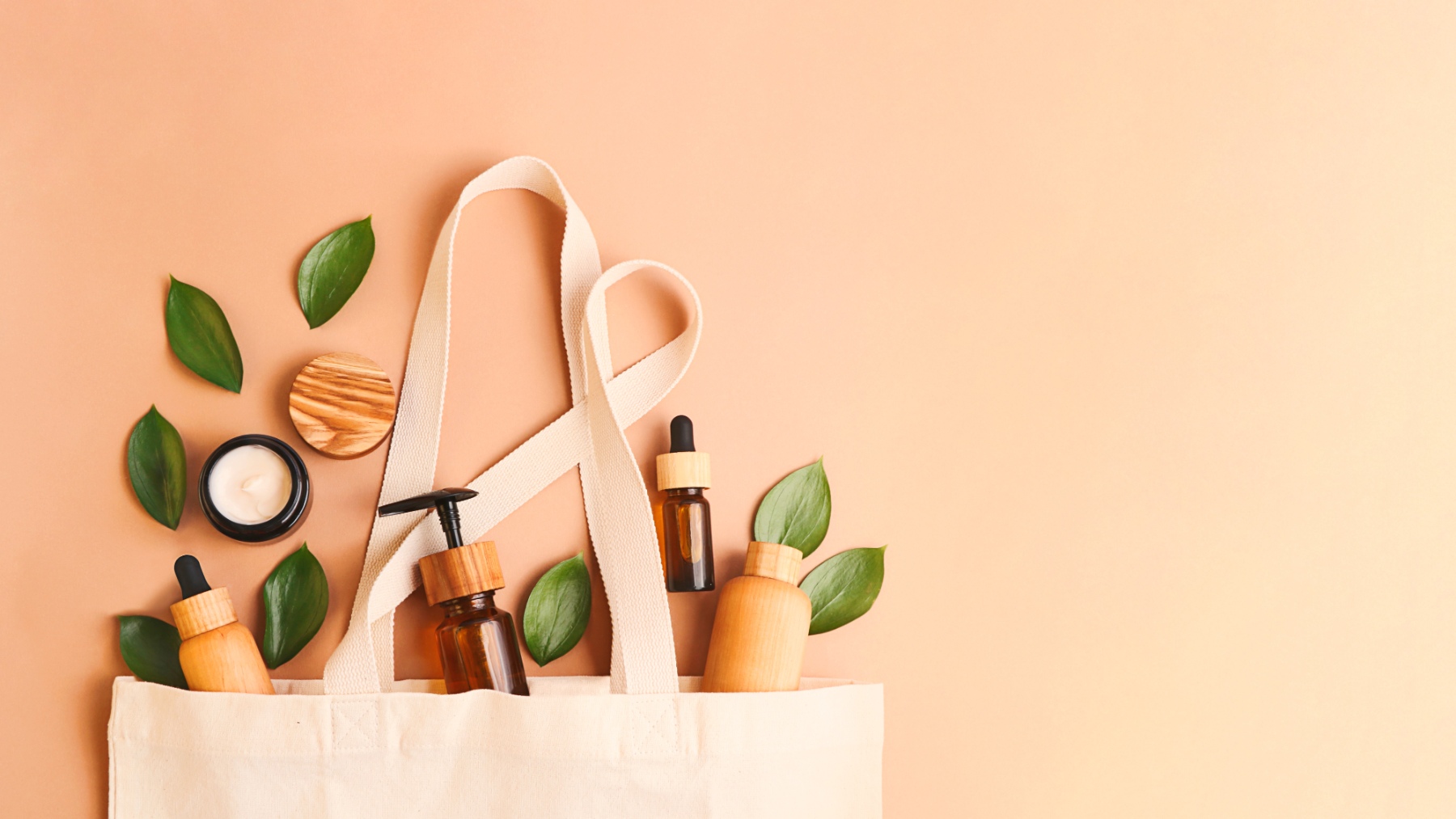 Bolsa de tela con productos de maquillaje vegano y hojas verdes