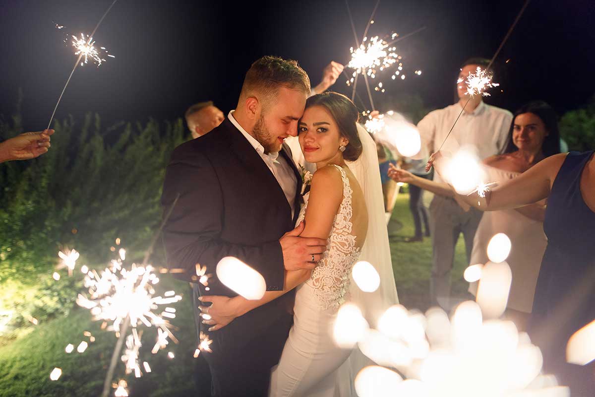 Novios celebrando con bengalas durante una boda de noche