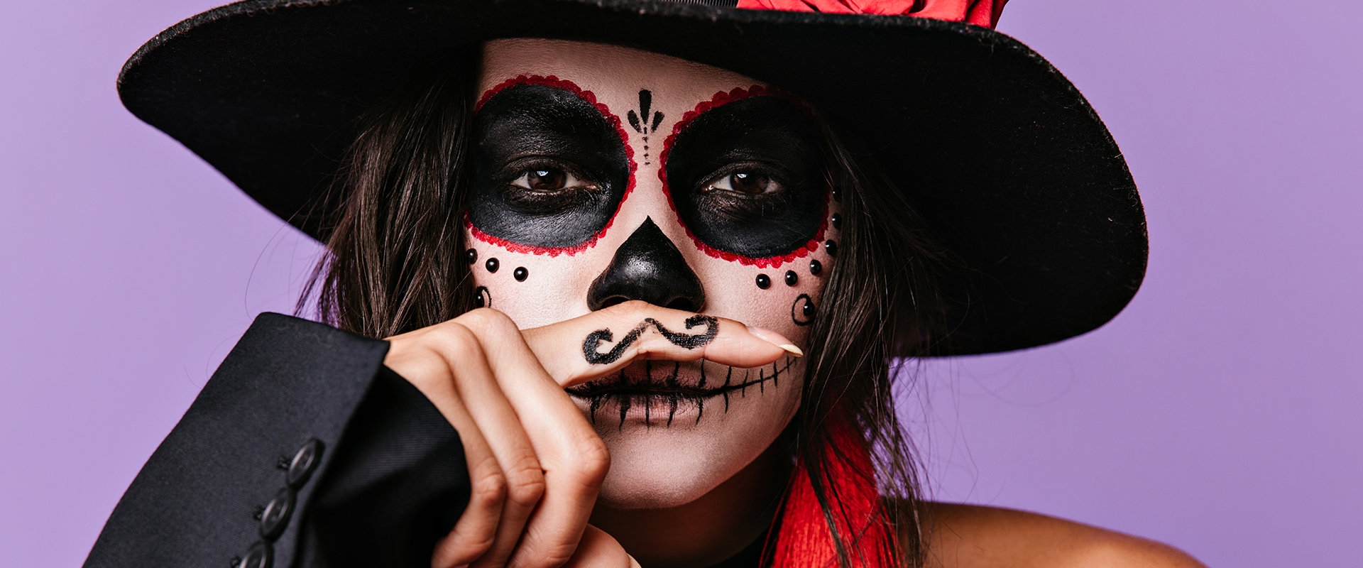 Mujer con maquillaje de catrina y sombrero negro para Halloween