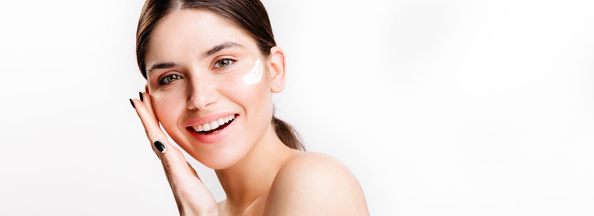 Mujer aplicándose corrector en el rostro