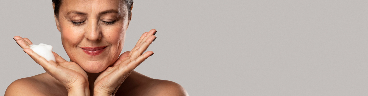 Mujer aplicándose crema sobre la piel sensible del rostro