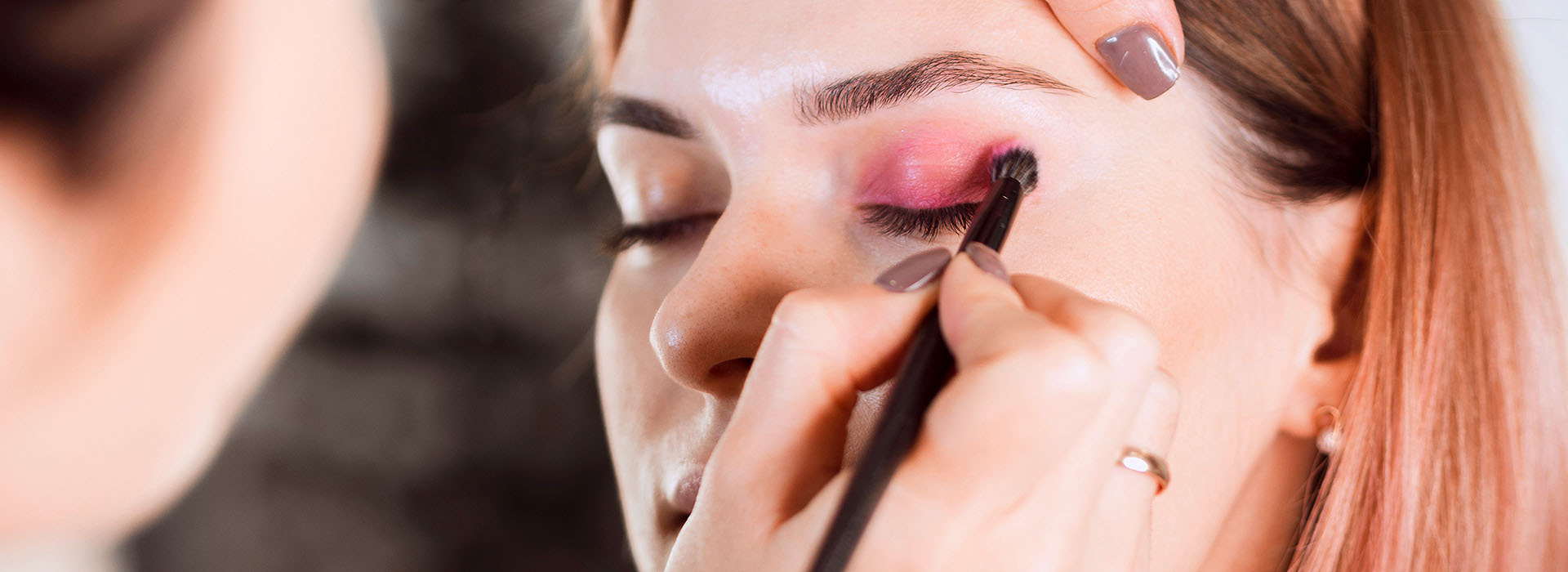 Maquilladora profesional trabajando el rostro de una clienta