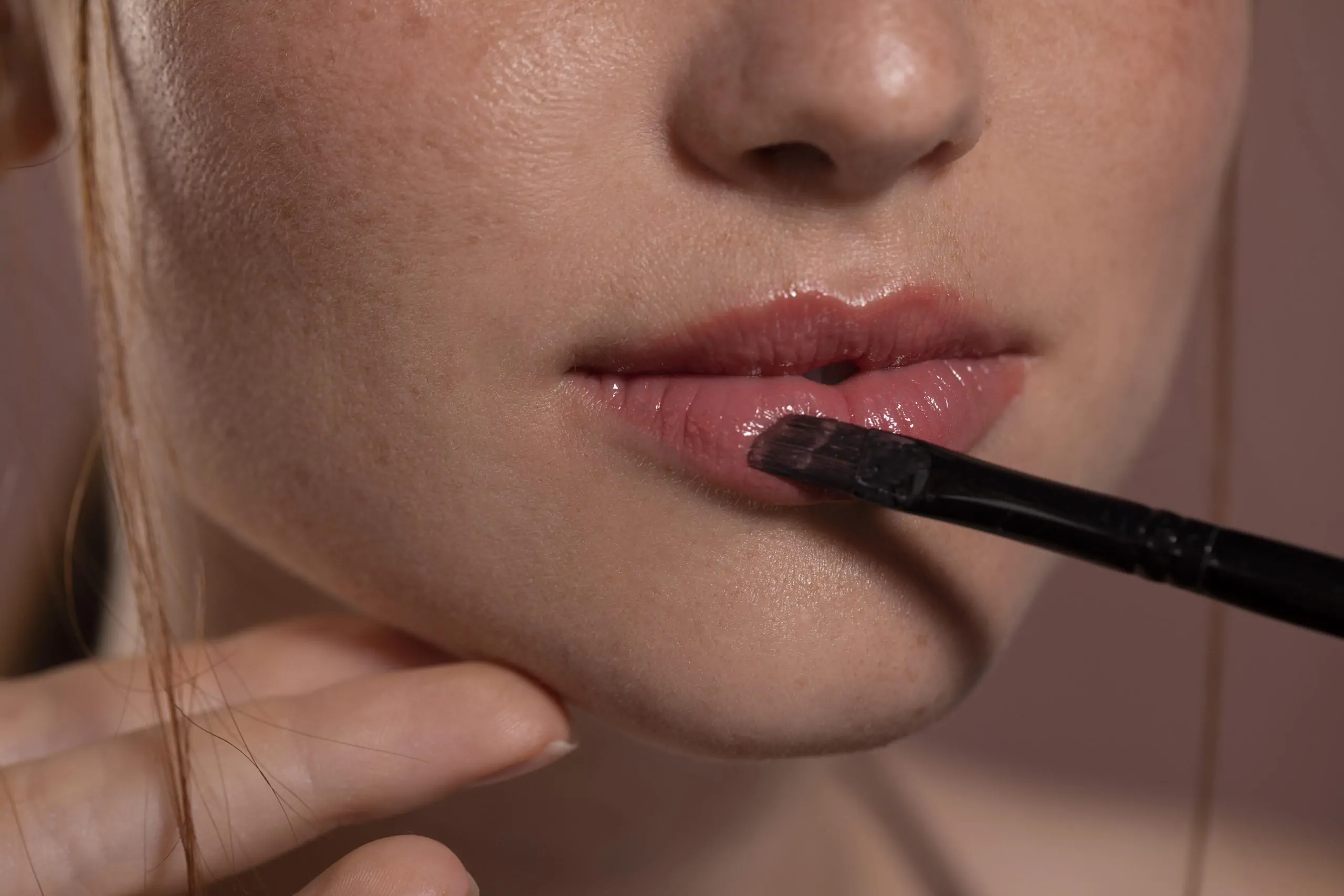 Perfilado de labios con un pincel para aumentar su volumen