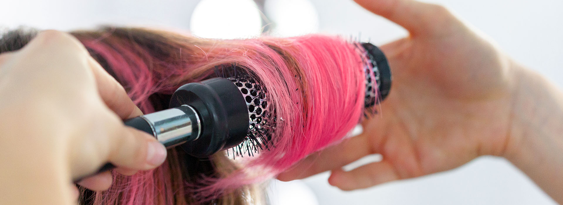 Peluquera aplicando color en un mechón de pelo