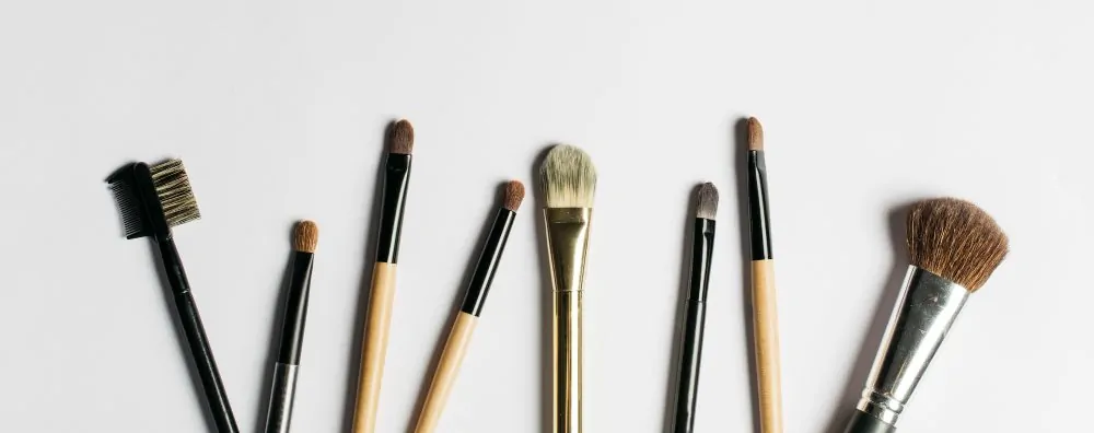 Brochas de maquillaje alineadas sobre una superficie clara