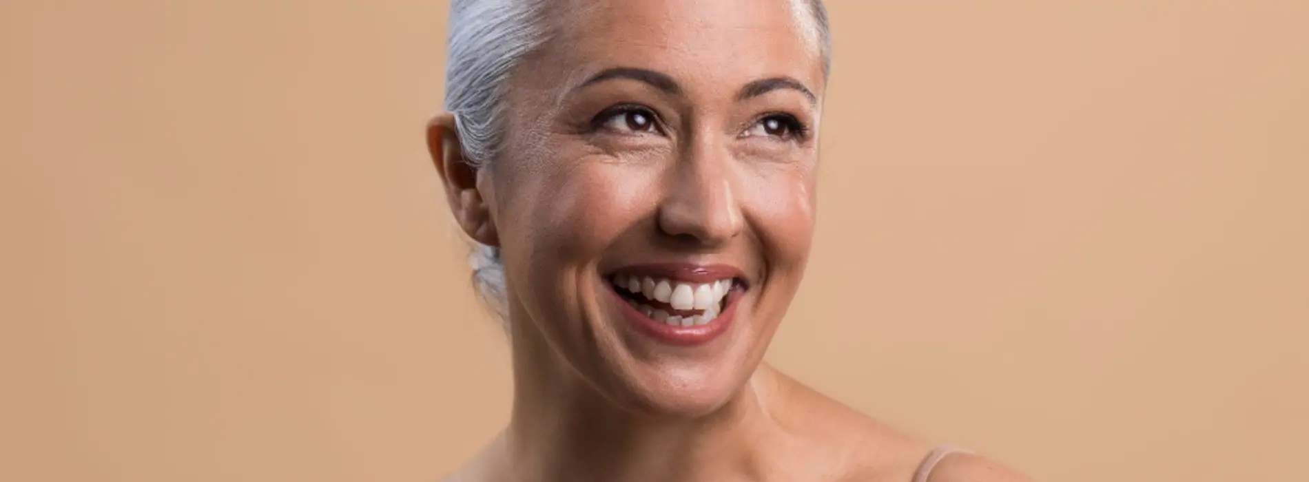 Mujer de pelo blanco sonriente con la piel cuidada